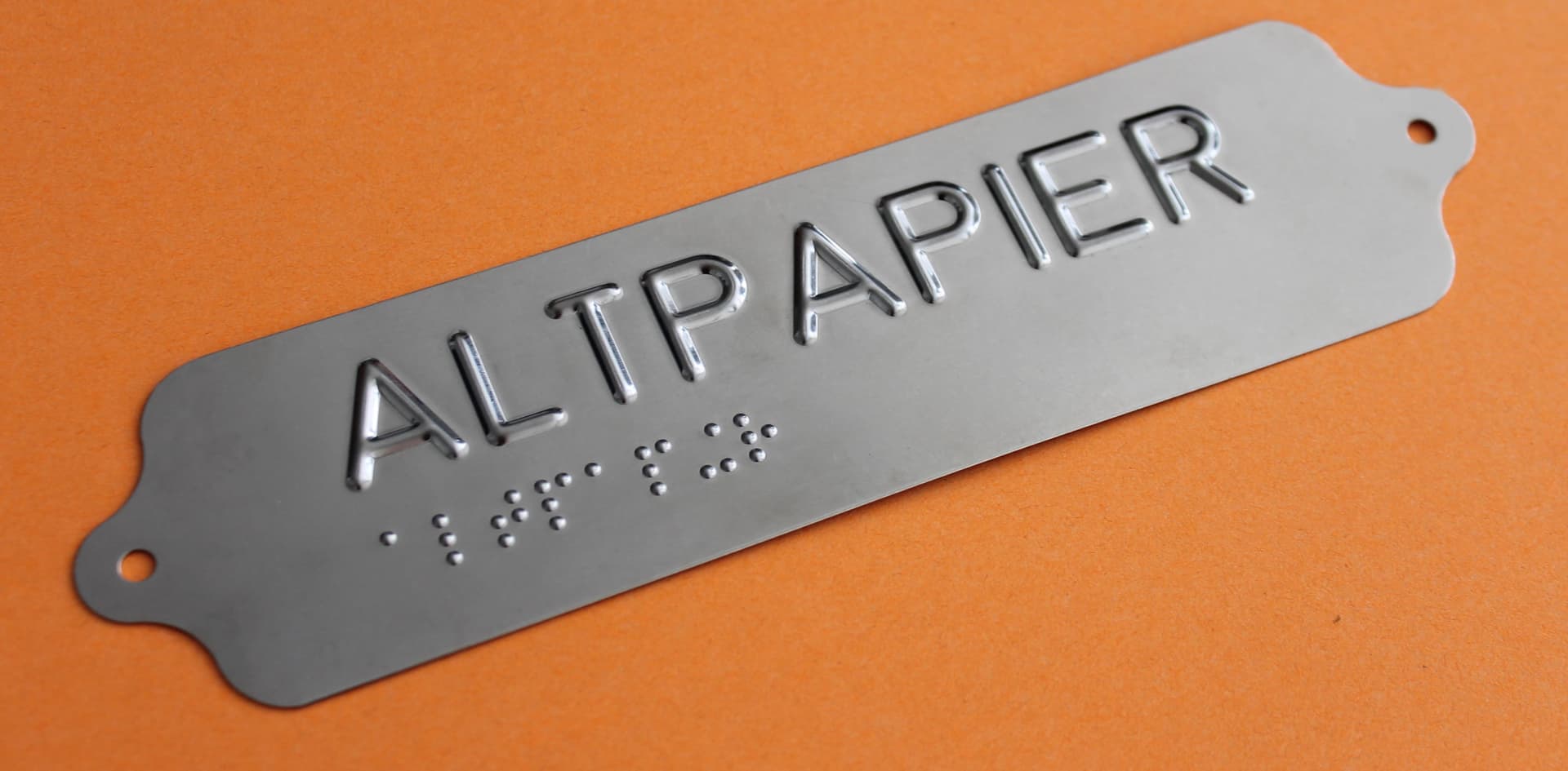 Schild mit dem Wort Altpapier als Blindenschrift