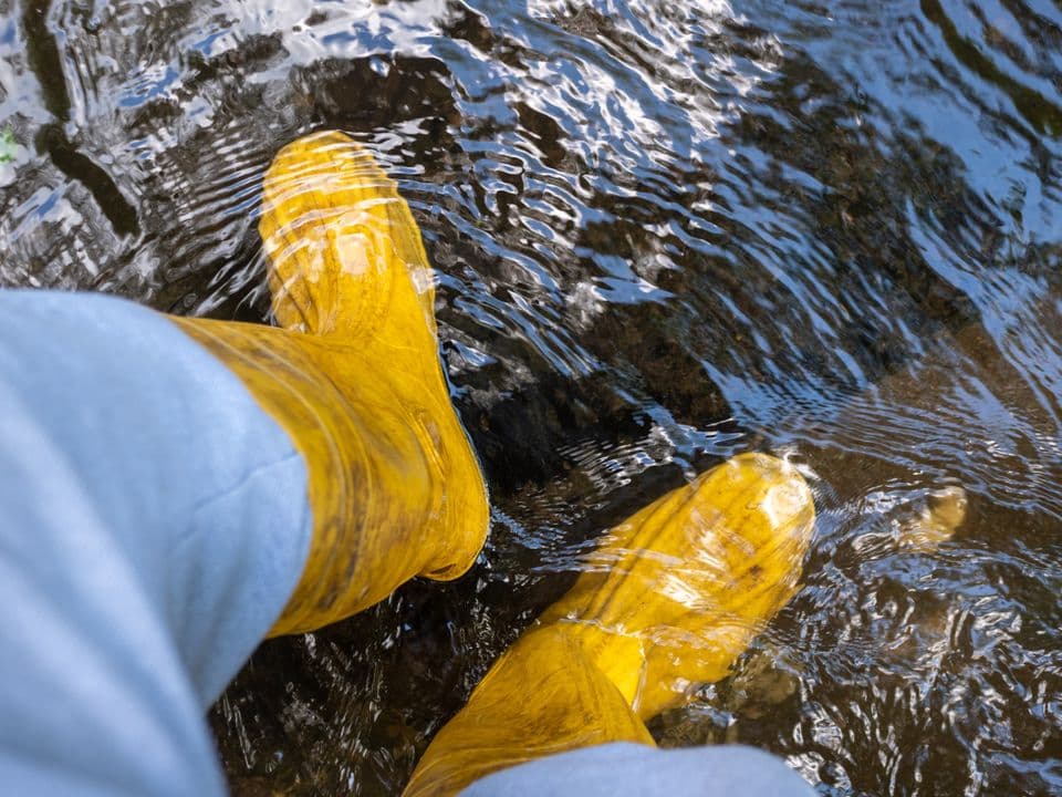 Kellerüberflutung Gelbe Gummistiefel im Wasser
