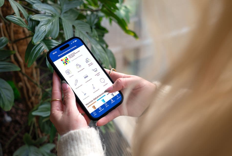WBD App Frau hält Smartphone in der Hand, man sieht die geöffnete WBD App.