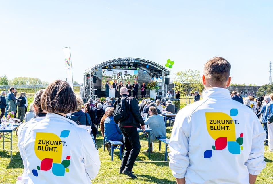 Zukunft blüht Veranstaltung im Freien, Zukunft blüht , zwei Mitarbeiter schauen zur Bühne
